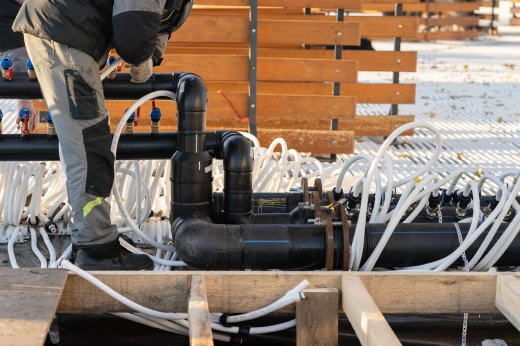 A professional plumber installing a complex PVC pipe manifold for a custom concrete swimming pool in Las Vegas, NV, ensuring proper water flow.