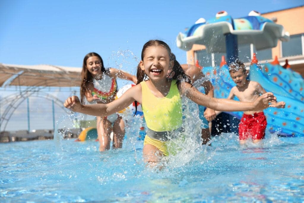 A happy family having fun splashing in a swimming pool at a family water park in Orlando, FL.